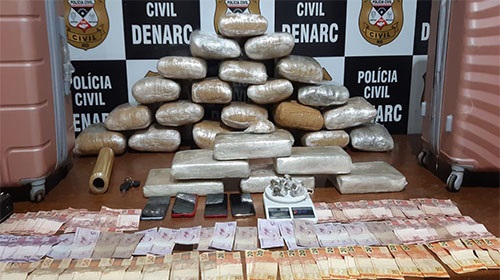 Quatro meses depois da prisão em flagrante por comercializar drogas em casa, a justiça condenou o casal Gleitieli Cunha Chagas e Jeferson Henrique da Silva Rabelo. A sentença é do juiz da 2ª Vara de Delitos Tóxicos da comarca de Porto Velho. Jeferson foi condenado à pena de seis anos de reclusão, além de 600 dias-multa no valor de 79 mil e 200 reais. Gleitieli, à sete anos e dois meses, além de 720 dias-multa, no valor de 95 mil reais. O juiz destacou o esforço do Judiciário para que este e outros julgamentos ocorram num curto período, cumprindo todos os trâmites processuais, com oitivas de testemunhas, dos réus, audiências de instrução e julgamento, assegurando ampla defesa aos acusados, como prevê a legislação. “A celeridade processual tem um impacto positivo na sociedade. Isso significa que as pessoas podem obter Justiça de maneira mais eficiente e efetiva, com processos sendo concluídos mais rapidamente, os tribunais têm a capacidade de lidar com um maior número de casos, evitando o acúmulo de ações pendentes e diminuindo a espera por uma decisão judicial”, frisou o magistrado. Droga em malas O casal era alvo de investigação policial, e no dia dos fatos, segundo os autos, a polícia recebeu a informação de que os dois haviam obtido grande quantidade de droga. Uma testemunha policial informou movimentação estranha na residência, o que levou a crer que não se tratava apenas de comércio de roupas, pois a maioria das pessoas que chegava ao local não entrava pela loja, mas sim por uma entrada lateral. Além disso, foi observado que havia visitas frequentes de pessoas já conhecidas pelos policiais por envolvimento com o tráfico. Outro ponto que chamou a atenção do juiz ao analisar o caso, é que a porta do quarto do casal permanecia trancada por chave, foi necessário o uso da força para adentrar no cômodo, conforme relato policial. Gleitiele justificou que mantinha a porta trancada para evitar que seus filhos utilizassem seus perfumes. Entretanto, para o juiz, o alegado pela ré não passa de uma tentativa de justificar uma situação incomum, ilógica e fora da realidade. “A bem da verdade, tenho por seguro que o casal mantinha a porta trancada para evitar que as crianças e terceiros que frequentavam a residência tivessem qualquer contato com os ilícitos ali armazenados”, enfatizou. Duas malas grandes cheias de maconha (32kg) foram apreendidas. Jeferson, ao chegar em casa, confessou ser o proprietário. Além das drogas nas malas, também foram localizadas pequenas porções em meio às roupas dele. O casal confessou que guardava as drogas para um traficante que não quiseram identificar. Na decisão, o juiz destacou: “não estamos aqui falando de pequenas porções de entorpecentes que de fato poderiam ser escondidas dentro de um quarto ou cômodo, sem que o seu companheiro tivesse ciência. Estamos falando de duas malas grandes cheias de maconha (32kg), de modo que se torna incompreensível, incoerente e nada crível alegar o desconhecimento do armazenamento de grande quantidade de entorpecente dentro de um pequeno quarto, considerado ainda o forte o cheiro típico do produto”. Fonte: Assessoria de Comunicação Institucional Foto: rondonianoar.com.br