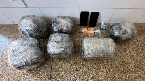 Na manhã desta quinta-feira (26), durante a Operação Horus na cidade de Nova Mamoré, as Forças de Segurança compostas pelo Batalhão de Polícia de Fronteiras e Divisas – BPFRON, canil, Força Tática, Núcleo de Inteligência – NI, 9º Batalhão de Polícia Militar – 9º BPM, SI em Nova Mamoré e o Serviço de Investigações e Capturas – SEVIC, da Polícia Civil, em Nova Mamoré, realizaram a prisão de duas pessoas do sexo masculino e, junto a eles, mais de seis quilos de entorpecente do tipo maconha (Skunk). Os polícias receberam a denúncia anônima que os elementos estariam negociando o entorpecente no bairro Planalto em Nova Mamoré e que o entorpecente seguiria para a cidade de Buritis, onde seria comercializado. De posse das informações, os policiais se deslocaram até o endereço e conseguiram interceptar a negociação que estava sendo feita na frente de uma residência. Além do entorpecente, foi apreendida uma motocicleta, dinheiro em espécie e dois aparelhos celulares que estavam sendo utilizados pelos suspeitos. Os suspeitos foram presos em flagrantes e encaminhados para a UNISP de Nova Mamoré, onde ficarão à disposição da autoridade policial. O Batalhão de Polícia de Fronteira e Divisas, possui um número de disque denúncias , onde a população pode realizar a denúncia anonimamente, sendo mantida em sigilo a identidade, através do número: (69) 9955-2005 (Whatsapp e ligações). Fonte: SITE/PM