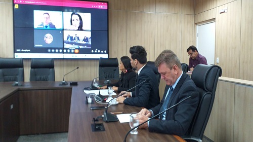 Reunião das mais concorridas na manhã desta terça-feira (24), na Comissão de Saúde, Previdência e Assistência Social da Assembleia Legislativa, presidida pela deputada Dra Taíssa (PSC). Convocado pela comissão, participou via online, o representante do Escritório das Nações Unidas de Serviços para Projetos (Unops), Rafael Esposel, gerente de projetos, que teve dificuldades para responder aos questionamentos dos deputados. A Unops tem com o governo do estado, via Secretaria da Saúde (Sesau), um Acordo de Cooperação Técnica para concluir o Hospital Regional de Guajará Mirim, obra iniciada na década de 90. O acordo prevê ainda a elaboração de projetos para o Cemetron e para nova Maternidade Estadual, além de fiscalizar e controlar os trabalhos. “Estamos no último trimestre de 2023 e nada foi feito”, disse a deputada Taíssa. Apesar de as obras não serem iniciadas, nem os projetos concluídos, o governo do estado, via Sesau, já liberou para a Unops mais de R$ 43 milhões no ano de 2020. Questionado pelo deputado Delegado Camargo (Republicanos), sobre os juros dos recursos, que foram repassados à Unops, Esposel disse que estão rendendo juros e os valores atualizados, e estão à disposição do Estado, caso a parceria seja rescindida. O prazo para conclusão das obras e projetos seria em dezembro de 2024, mas já foi prorrogado para dezembro de 2025, sem que as obras tenham iniciado. Há dias o governador de Rondônia, coronel Marcos Rocha (União Brasil) anunciou em órgãos de comunicação e redes sociais, que teria assinado a Ordem de Serviço (OS) para conclusão do HR de Guajará-Mirim. Segundo Esposel, não foi OS, mas sim uma autorização para contratação da empresa vencedora da licitação, onde foram convidadas 42 empresas e somente duas demonstraram interesse apresentando propostas. As obras de conclusão do HR de Guajará Mirim, segundo Rafael Esposel, serão iniciadas no dia 2 de novembro e com prazo de conclusão para dez meses. Os deputados aprovaram requerimentos, solicitando informações e cópias com um prazo de duas horas, após o recebimento dos documentos, sobre todos os contratos da Unops com o governo do estado, sob pena de responsabilização. Inclusive com os custos em separados dos projetos e construções. O deputado Luizinho Goebel (PSC) disse que em passado recente solicitou os mesmos documentos, inclusive cópias dos contratos para a Unops, mas que não foi atendido. Delegado Camargo lamentou que a Unops não tenha um portal no Brasil, tem somente no exterior, e que não são publicadas suas ações, mesmo “administrando” recursos financeiros públicos, como no caso dos projetos e construção de obras em Rondônia. Texto: Waldir Costa I Secom ALE/RO Foto: Rafael Oliveira I Secom ALE/RO