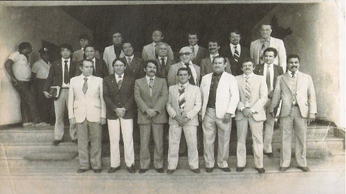 Há quatro décadas, a Constituição Estadual de Rondônia era promulgada, marcando o nascimento do Poder Legislativo com uma mensagem de liberdade, justiça e progresso. Os 24 deputados constituintes, representando a voz do povo rondoniense, destacaram no preâmbulo da Carta Magna “o propósito de assegurar os princípios de liberdade e justiça, de favorecer o progresso sócioeconômico e cultural”, entre outras coisas. A partir daquele momento, tinha início um novo capítulo na história política do estado. A primeira Constituição de Rondônia foi promulgada em 6 de agosto de 1983. Até essa data, o então governador Jorge Teixeira exercia o papel de legislador do Estado por meio de decretos-lei. Foi a partir dessa data que houve a efetiva implantação do Poder Legislativo, extinguindo-se a Assembleia Constituinte, formada para definir os rumos do Estado por meio de sua Constituição. A Assembleia Constituinte A primeira eleição do estado ocorreu em 15 de novembro de 1982. À época, foram eleitos representantes para o Senado, a Câmara Federal e a Assembleia Legislativa. Os 24 deputados estaduais eleitos naquele pleito receberam a função de constituintes, 15 pertenciam à legenda PDS e nove à do PMDB. Os constituintes foram: Amizael Silva, Arnaldo Martins, Heitor Costa, Francisco Nogueira, Genivaldo Souza, Jacob Atallah, José Bianco, José do Prado, Jô Sato, Manoel Messias, Marvel Falcão, Oswaldo Piana, Silvernani Santos, Walderedo Paiva, Zuca Marcolino, Amir Lando, Ângelo Angelim, Cloter Mota, Jerzy Badocha, João Dias, Ronaldo Aragão, Sadraque Muniz, Sérgio Carminatto e Tomás Correia. O processo de instalação da Assembleia se deu sob a liderança do desembargador Darci Ferreira, presidente do Tribunal Regional Eleitoral, à época. O primeiro presidente da Mesa Diretora foi José de Abreu Bianco, com outros membros como Ângelo Angelim e José Ronaldo Aragão. Os trabalhos da Assembleia Constituinte foram realizados de 1° de fevereiro a 6 de agosto de 1983, tendo como palco o Palácio Teotônio Vilela, anteriormente um hospital desativado. Foram formadas seis Comissões Temáticas para elaborar a constituição, tratando de diversos temas que incluíam desde disposições preliminares até questões de família, educação e cultura. Ao final, foram realizadas 60 sessões ordinárias. Dos membros da Assembleia Constituinte, apenas dois tinham experiência administrativa anterior: os deputados Zuca Marcolino e Arnaldo Martins. O fato ressalta o caráter pioneiro e desafiador da tarefa que receberam. No período, os deputados ficaram impedidos de legislar, no entanto, encaminhavam indicações, requerimentos, moções, mas sem poder tomar qualquer atitude contra ações de autoria do Governo do Estado, o que gerou os primeiros conflitos entre o Poder Executivo e a Assembleia Estadual Constituinte. Além do trabalho constituinte, o período foi marcado por eventos políticos de grande importância, incluindo a eleição da segunda Mesa Diretora em 1985, a representação do Estado no Colégio Eleitoral para a escolha do Presidente da República, e a nomeação do vereador José Guedes para a prefeitura da capital. A promulgação da Constituição e a consequente extinção da Assembleia Constituinte ocorreu em 6 de agosto de 1983, dando lugar à Assembleia Legislativa. Os anos subsequentes testemunharam uma série de eventos políticos importantes, incluindo mudanças na Assembleia Legislativa e conflitos entre o legislativo e o executivo. Este período tumultuado foi fundamental para a construção do estado de Rondônia moderno que conhecemos hoje. Texto: Ivanete Damasceno | Secom ALE/RO Foto: Acervo Alero