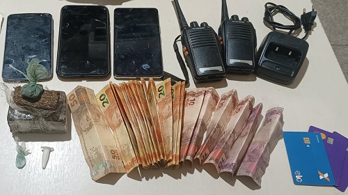 Durante patrulhamento de rotina, na noite da última terça-feira, 28, uma guarnição de Força Tática do 2º BPM avistou uma motocicleta com restrição de furto/roubo na varanda de uma casa, na rua Belo Horizonte. Então os militares adentraram ao local onde foram abordados três homens e uma mulher. Em uma busca na residência, foram encontrados 140 g de uma substância aparentando ser maconha e duas porções de cocaína. No local, também foram apreendidos dois rádios comunicadores, uma roçadeira com procedência duvidosa e dinheiro. A motocicleta recuperada, juntamente com a droga, os objetos e os suspeitos foram conduzidos para a Unidade Integrada de Segurança Pública para o registro da ocorrência e providências que se fizerem necessário. Texto: P5 do 2º BPM | 2º sargento PM Soares Informações: Boletim de Ocorrência Policial