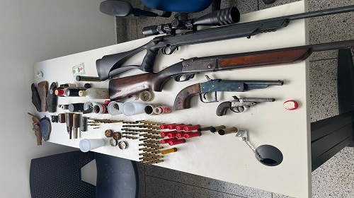 A Polícia Militar de Rondônia, apreendeu ontem, 28, por volta das 7h40, na linha 01, zona rural de Buritis, várias armas e munições e prendeu o proprietário da residência por porte ilegal de arma de fogo. De acordo com a PM, uma equipe da inteligência obteve informação anônima, que no local, sentido Rio Pardo, morava um foragido da Justiça, acusado de ter assassinado o seu cunhado e suspeito de vários outros homicídios na região e que em sua casa, teriam várias armas de fogo e munições. Contra o acusado, consta um mandado de prisão expedido pela comarca de Espigão do Oeste. Como ele não foi encontrado, o proprietário da residência foi conduzido à delegacia por posse ilegal de arma de fogo. Com autorização do dono da moradia, os policiais militares encontraram na casa, os seguintes armamentos e munições: um rifle calibre .22 (com luneta) alimentado e carregado; uma espingarda calibre .16; uma garrucha calibre .38; uma garrucha calibre .22 carregada; duas munições calibre .12 deflagradas; 10 munições calibre .16 intactas; uma munição calibre .20 deflagrada; uma munição calibre .32 deflagrada; 16 munições calibre. 38 intactas; 40 munições calibre .38 deflagradas, 19 munições calibre .380 deflagradas; duas munições calibre .40 deflagradas; uma munição calibre .32 deflagrada; seis munições calibre .40 deflagradas; oito munições calibre . 22 intactas; seis munições calibre .22 deflagradas; 2.190 kg de chumbo; 157 gramas de pólvora; três socadores de pólvora; um calibrador para calibre .36; um conjunto de alça e maça do rifle. 22; e cinco coldres para revólver/pistola. Segundo o proprietário da residência, o armamento e munições pertencem ao seu filho, mas como ele não foi localizado e diante dos fatos constatados, aquele recebeu voz de prisão pelo crime de posse ilegal de arma de fogo e apresentado à autoridade policial para providências que o caso requer. Fotos: PM Buritis Fonte: Diretoria de Comunicação Social da Polícia Militar de Rondônia